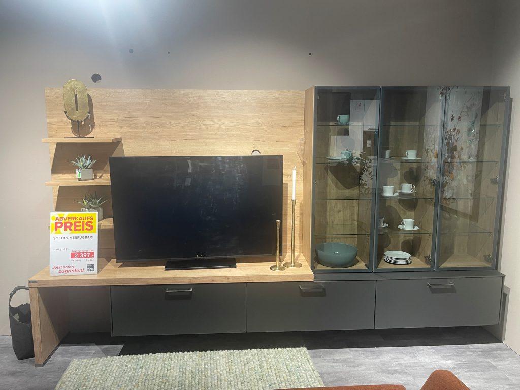 Wohnwand mit Vitrine und Abverkaufs-Preisschild in der Ausstellung