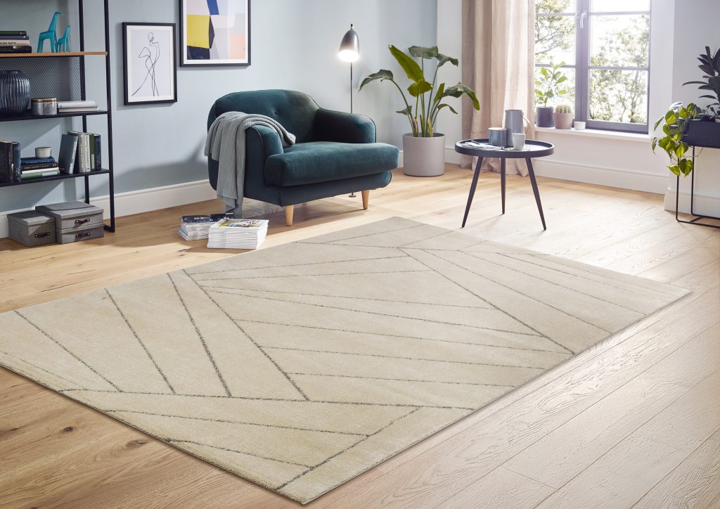Heller Teppich mit Fischgrätmuster in einem Wohnzimmer mit blauem Sessel